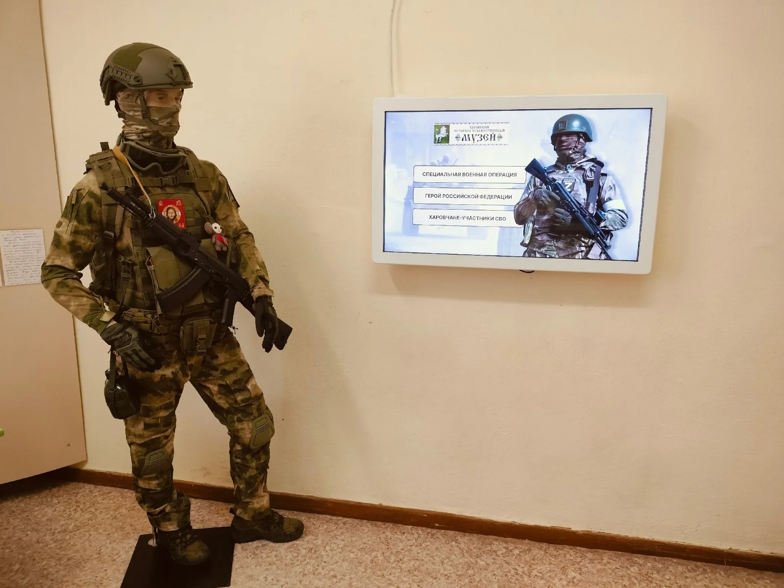 Интерактивная панель в экспозиции музея рядом с витриной экипировки